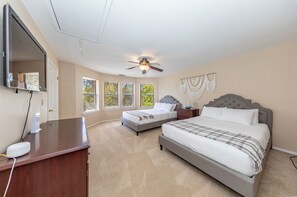 A bedroom with two beds, a ceiling fan, a desk with a computer, and a large window. - Yosemite+Bass Lake -Hot tub,Game room,BBQ (Oakhurst)