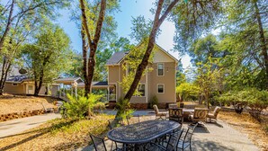 A residential area with a house, patio furniture, and a garden.