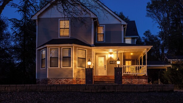 A two-story house with a porch, a front door, and a small staircase leading to the entrance. - Yosemite+Bass Lake -Hot tub,Game room,BBQ (Oakhurst)