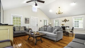 A spacious living room with a high ceiling, a dining area, and a kitchen. - Chic Marigny Retreat Near French Quarter (New Orleans)