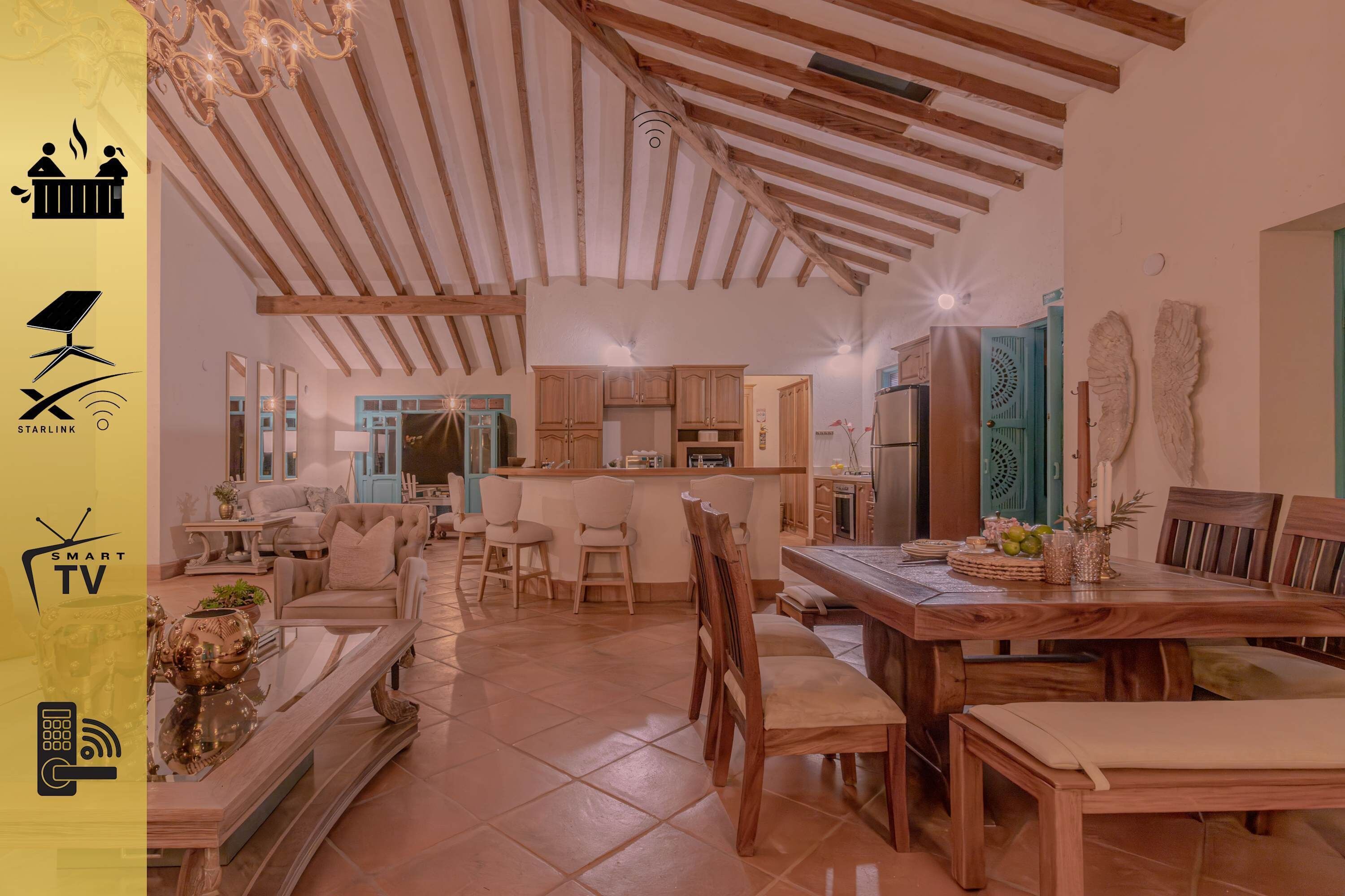 Un vaste espace de vie doté d’un plafond en bois, d’une table à manger et d’une cuisine située au fond de la pièce.