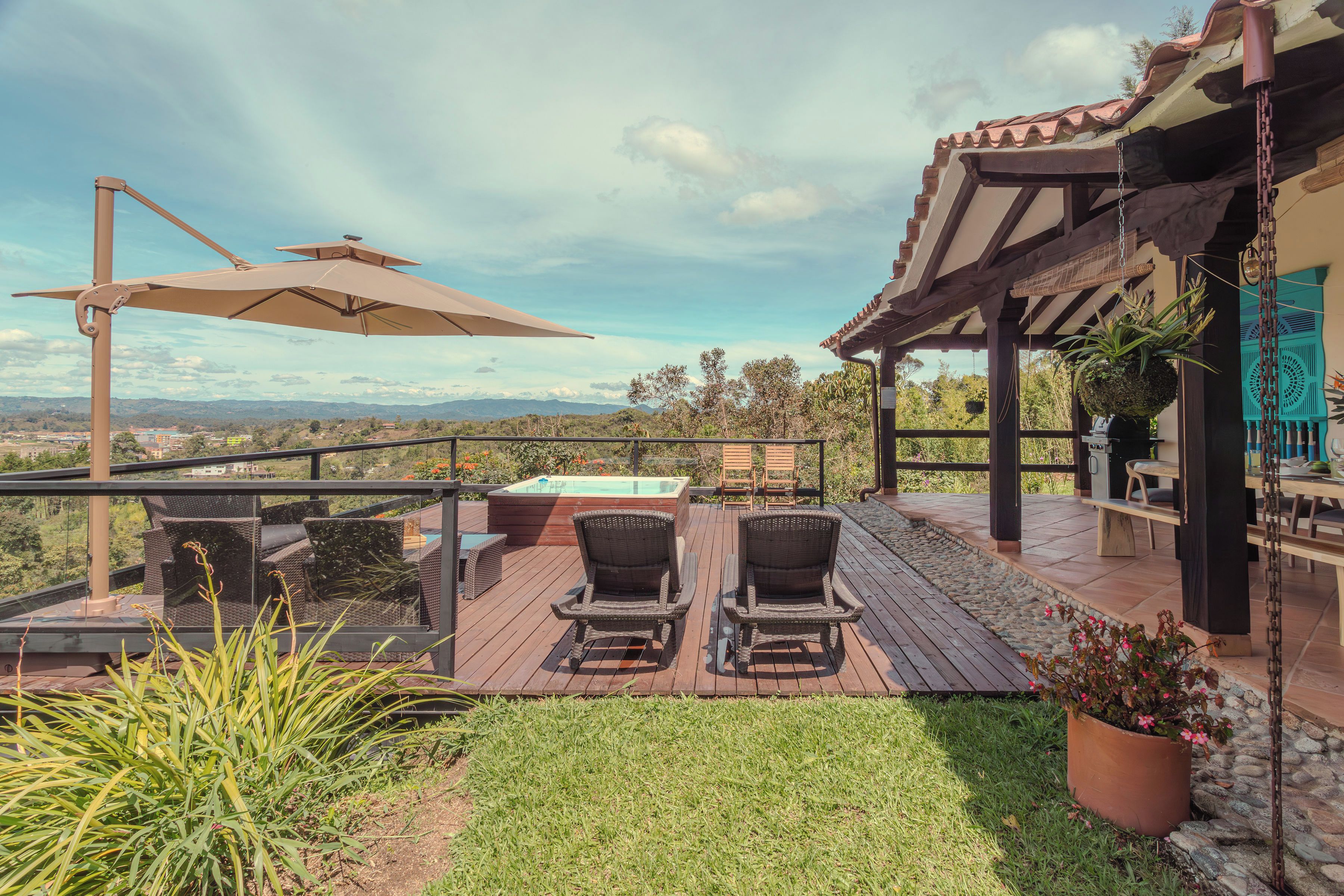 A patio with outdoor furniture, a hot tub, and a view of the landscape.