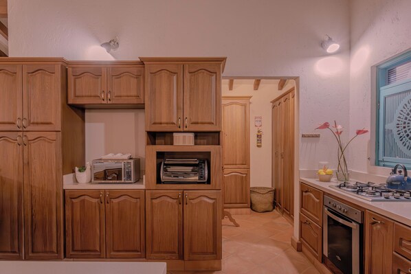 A kitchen with wooden cabinets, a built-in oven, a microwave, and a gas stove.