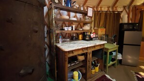 Una cocina rústica con estantes de madera, encimera de mármol y barra para café.