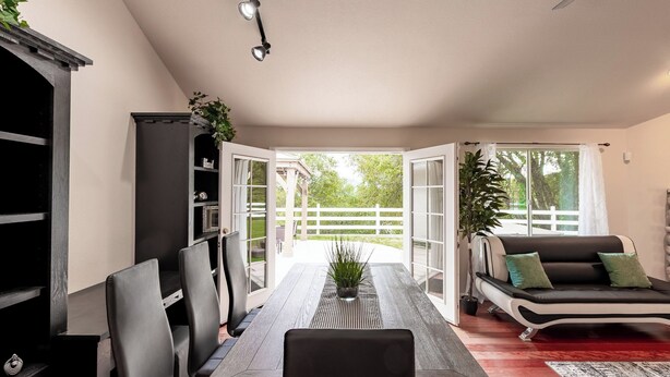 A dining area with a long table, chairs, a sofa, and a potted plant. - Yosemite + Bass Lake – Hot Tub, Games, Sleeps 13 (Oakhurst)