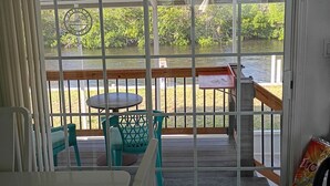 A room with a sliding glass door leading to an outdoor deck with a table and chairs.
