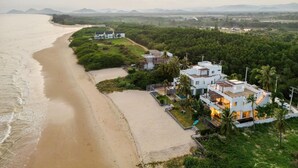 A coastal property with a beach, a pool, and a large house with multiple levels and a modern design. - Peaceful Beachfront Pool Villa – Kui Buri (Bangkok Bo Nok, Kuri Buri)