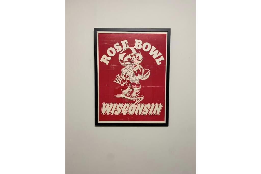 Ein gerahmtes Poster mit einem Fußballspieler und dem Text „Rose Bowl Wisconsin“.