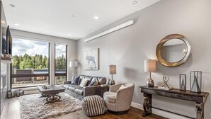 A modern living room with a sofa, armchair, coffee table, and a console table with decorative items.