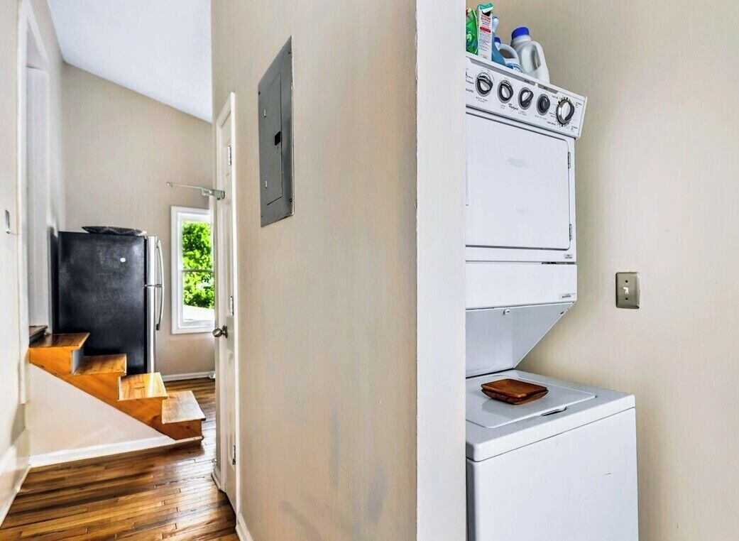 A laundry room with a white washing machine, a dryer, and a small cabinet with toiletries.