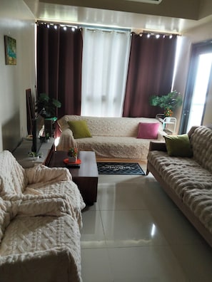 Una sala de estar con dos sofás, una mesa de centro y un mueble de televisión con una planta.