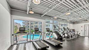 A gym with treadmills, a pool view, and a modern ceiling design. - Waterfront Condo with Pool, Spa, and Fitness Center near Downtown Sarasota (Sarasota)