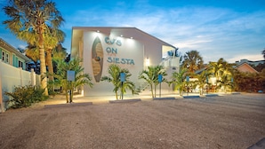 A building with a sign reading "CJ's on Siesta" and palm trees in front.