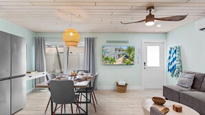 A modern kitchen with a dining area, a ceiling fan, and a view of the outside. - Sea Escape - Pet Friendly, Located in Siesta Key Village, Steps to Siesta Key Beach! (Siesta Key)