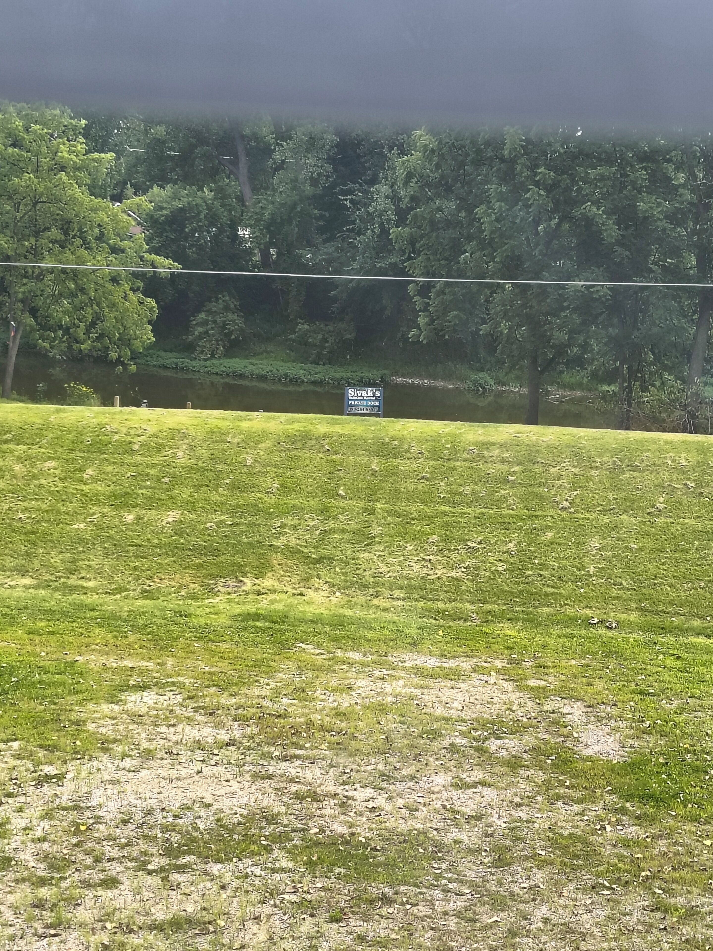 A grassy area with a sign for "Slivak's Private Dock."