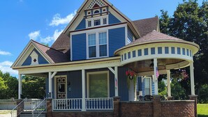 A two-story house with a porch, a garage, and a well-maintained lawn.