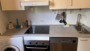 A kitchen with stainless steel appliances, a dishwasher, and a washing machine. - Apartment with sea view relaxation and peace (MONEGLIA)