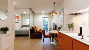 Un apartamento moderno con cocina, comedor y sala de estar con sofá y televisor.