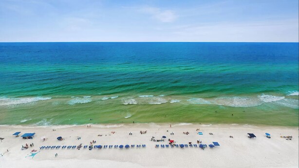 A beach with clear turquoise waters and a sandy shore.