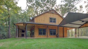 A two-story wooden house with a covered porch and a large garage.