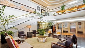 A spacious lobby with a central seating area, a staircase, and multiple levels. - Luana Waikiki Hotel & Suites (Honolulu)
