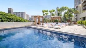 A swimming pool with lounge chairs and a gazebo. - Luana Waikiki Hotel & Suites (Honolulu)