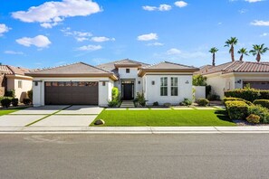 A residential house with a garage, a front lawn, and a driveway.