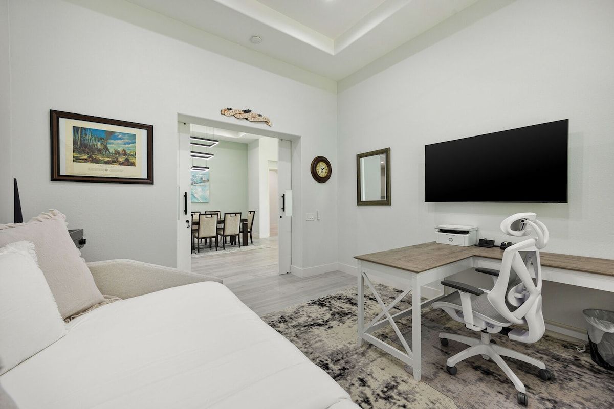 Quarto moderno com uma cama, uma escrivaninha e uma televisão.