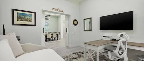 A modern bedroom with a bed, a desk, and a TV.