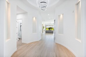 A modern hallway with a curved ceiling and recessed lighting.