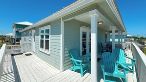 A light blue house with a wooden deck and two turquoise Adirondack chairs. - 200 Steps To Beach, Balcony Gulf Views, Firepit, Dog Friendly, 3BR Beach Home (Gulf Shores)