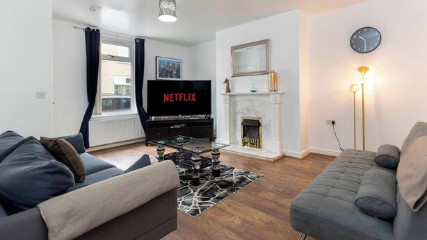 A living room with a fireplace, a television, and a sofa.