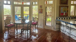 A dining area with a table and chairs, a chandelier, and large windows. - Heidi's Artistic Abode, peaceful relaxation! (Three Rivers)
