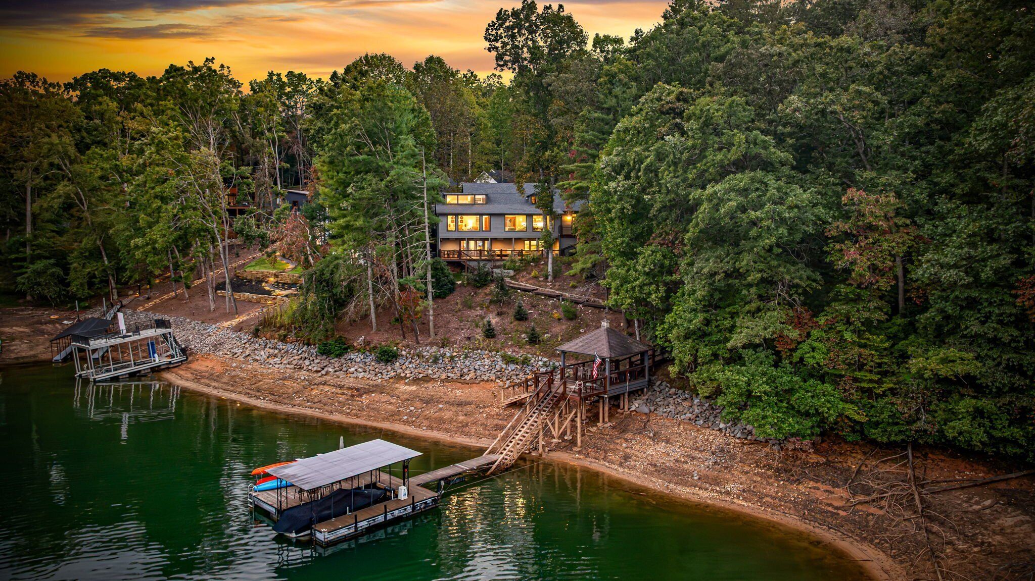 A lakeside cabin with a dock, surrounded by dense forest.