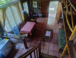 A cozy dining area with a checkered tablecloth, wooden chairs, and a tiled floor.