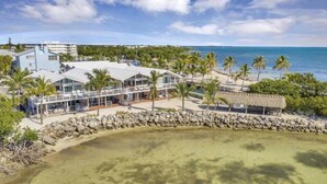A coastal hotel with a beach view, a pool, and a thatched-roof structure. - Amazing Ocean Front Views 3 bedroom / bath Villa. Wake up to a Sunrise (Key Largo)