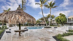 A pool area with lounge chairs and a thatched umbrella. - Amazing Ocean Front Views 3 bedroom / bath Villa. Wake up to a Sunrise (Key Largo)