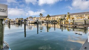 A marina with docked boats, a clear sky, and buildings with balconies. - Amazing Ocean Front Views 3 bedroom / bath Villa. Wake up to a Sunrise (Key Largo)