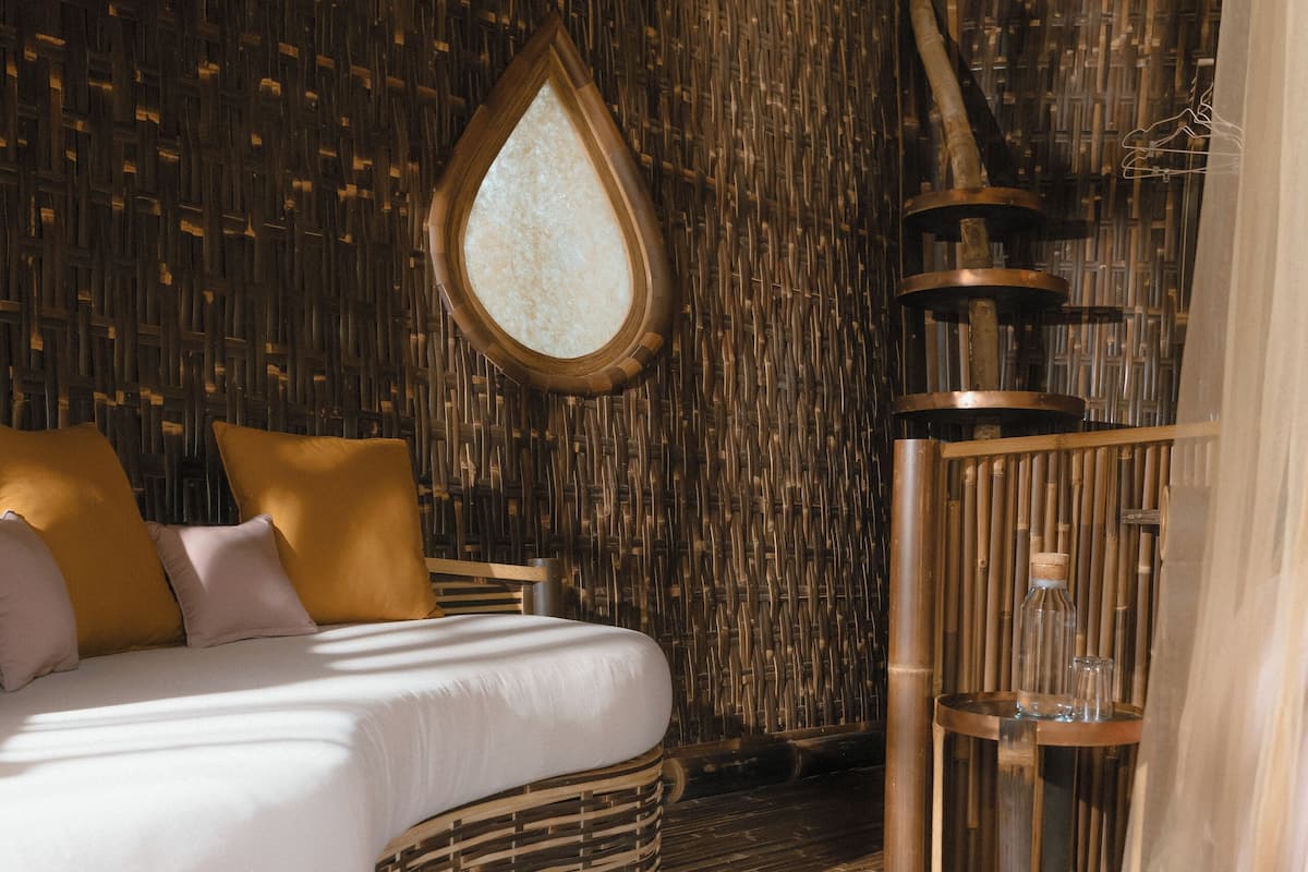 A room with a bed, a circular mirror, and a wooden wall.