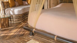 A room with a bed, a glass table, and a bamboo floor. - The Kul Kul Farm (Abiansemal)