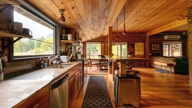 Una cocina amplia con pisos de madera, una isla central y un ventanal con vistas al exterior.