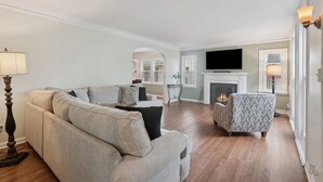 A living room with a sofa, armchair, and a fireplace.