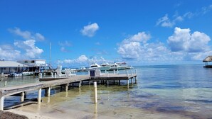 Un port de plaisance avec des bateaux amarrés, une jetée et un petit bâtiment portant l’inscription « MAR ».