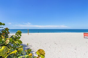 Een strand met een bank en een touwbarrière.