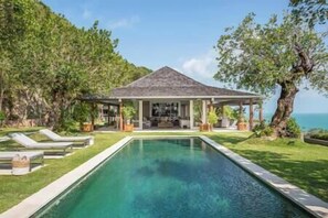 A pool with a covered seating area and lounge chairs. - Element of 8 at Cape Laem Sor Estate by Elite Havens (Surat Thani)