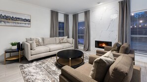 A modern living room with a sofa, coffee table, and fireplace. - Two Kings, Heated Pool, Whirlpool Jet Bathtub &BBQ (Flower Mound)