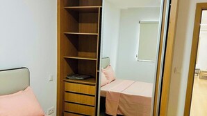 Een slaapkamer met een bed, een kast en een spiegel.