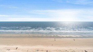 Una playa con cielo despejado y mar tranquilo.