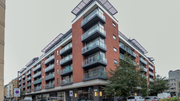 En bygning med flere etager i moderne arkitektur, med altaner og store vinduer.