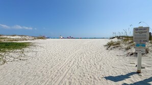 Una playa arenosa con un cartel que dice 'Deja solo huellas' y 'Corrientes de resaca'.